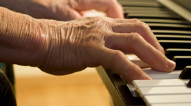 Forskningsprojektet Musik og Folkesundhed. Billedet viser ældre hænder, der spiller klaver.