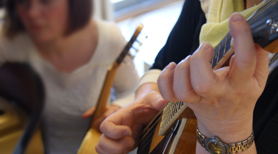 Forskningsprojektet Procesorienteret Musikterapi (PROMT) med personer med personlighedsforstyrrelse. Billedet viser hænder på en guitar.