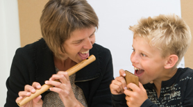  Center for Dokumentation og Forskning i Musikterapi. En musikterapeut spiller fløjte med en dreng.